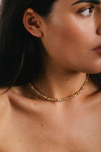 Collier Vénus Champagne porté de profil, surface asymétrique aux reflets dorés