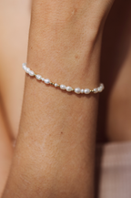 Bracelet Grain de riz porté au poignet, perles de culture et perles d'or