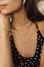 Collier Grain de riz perle rose porté en superposition de chaînes dorées