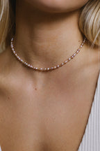 Collier Grain de riz perle rose porté en ras de cou, or laminé 585/1000