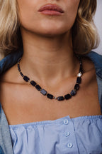Collier Louise porté sur une chemise bleu clair, enfilage de sodalites