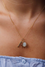 Pendentif Victoire aigue-marine porté en superposition de chaînes