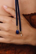 Pampille de lapis-lazuli du collier Antoinette tenue à la main