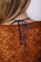 Collier Antoinette bleu foncé porté de dos, nœud dans le dos