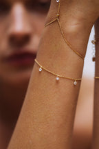 Bracelet Sofia porté au poignet, trois diamants en pampille suspendus à une chaîne d'or 18 carats